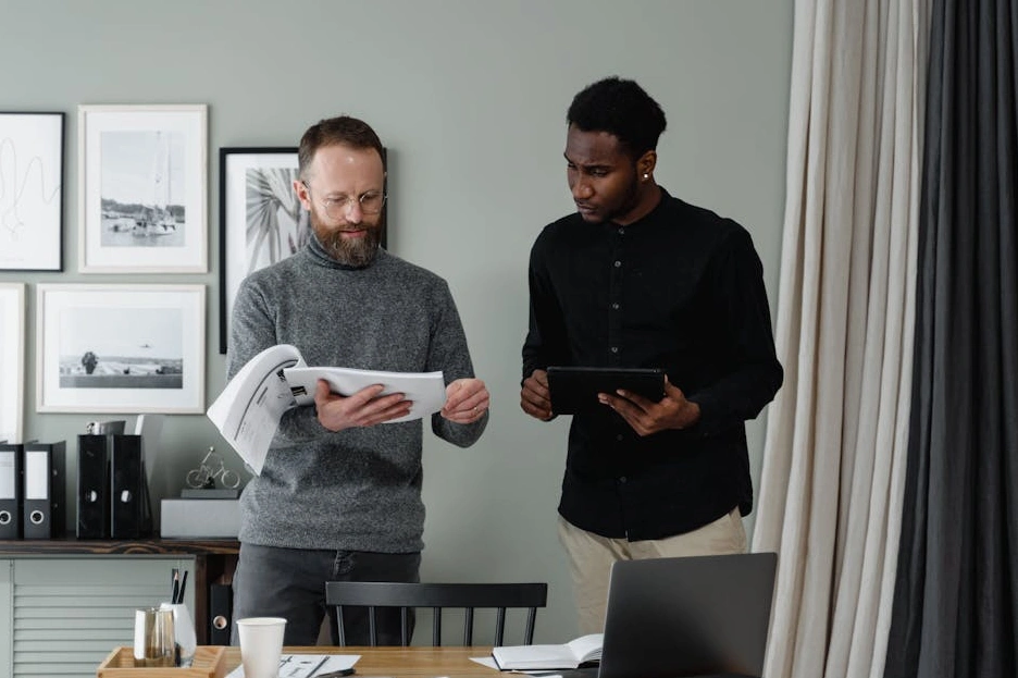 Persona sorridente che inserisce dati in un foglio di calcolo sul proprio laptop.